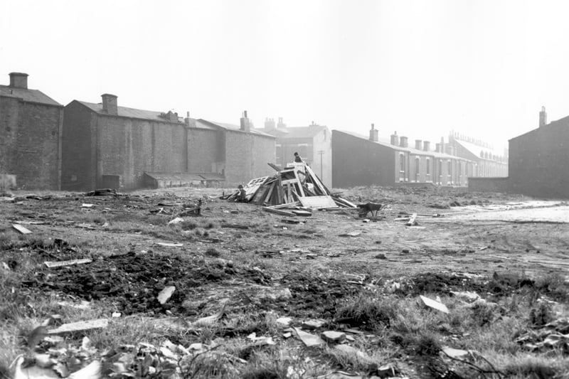 Waste land next to Devon Terrace in October 1966. The land is littered with industrial debris and two boys, pictured, have built the beginnings of a bonfire in the centre.