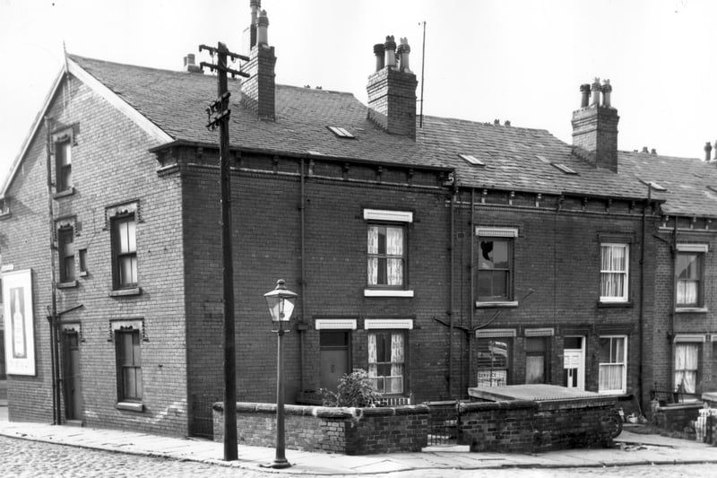 Devon Crescent in October 1966. This photo shows the side and rear of shops on Pontefract Lane. Each through terrace has a private entrance and garden. No 13 is the run down rear of Lee Ward & Co Ltd Television and Electrical Contractors. On the far left, just visible is an advertising hoarding promoting gin and on the Devon Crescent, Devon Grove Corner is a streetlight and electricity pylon.