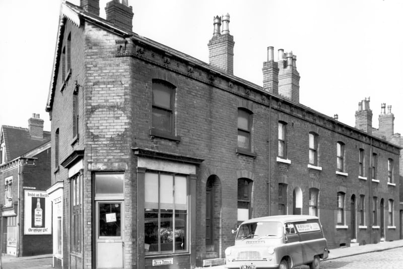 W. Bean & Son practical upholsteres and furnishers on the corner of Devon Terrace on the left. On the right are back-to-back houses with a yard originally built to house the shared outside toilet and midden. A van belonging to the upholsterers is parked outside the shop and on the far left just visible on the side of Devon Grove is an advert for Booths Unique Gin. Pictured in October 1966.