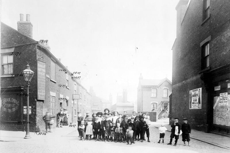 Taken from Waterloo Road, looking down Bower Row prior to the Waterloo Road improvements. On the right is an empty unidentified retail premises, next to this is a large poster advertising Taylor's Drug Co. Further down the street is a house called Claremont House which has wooden carts in the yard. Towards the rear of the street, which is a cul-de-sac, it is possible to see the rear of the Grey Mare Inn which is located on Low Road beyond. Pictured in August 1904.