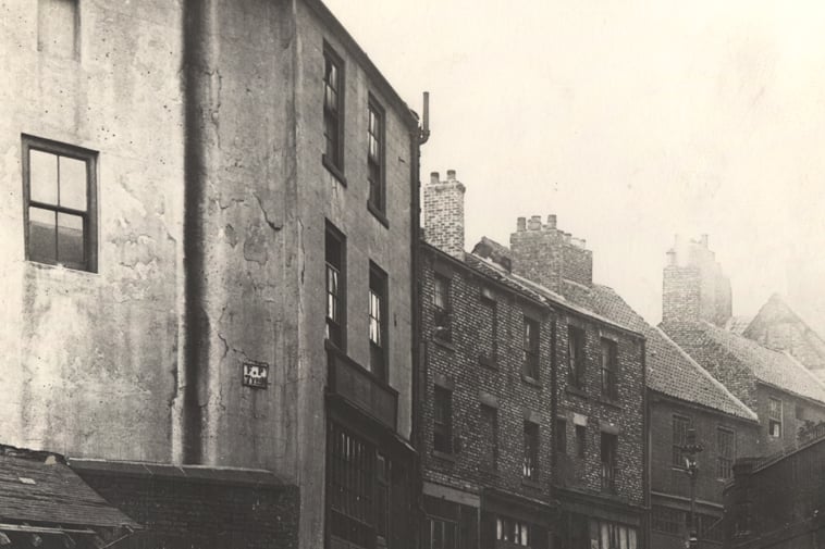 A view of Pilgrim Street Newcastle upon Tyne taken in 1924. The photograph is looking up the lower part of Pilgrim Street. In the foreground to the left there is flight of stairs which leads up to the buildings on the left-hand side of the street.