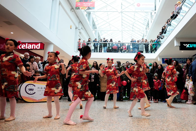 A children's dance group performing for the large crowd