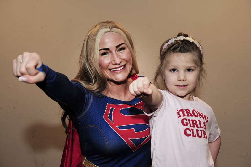 India buckle, five, poses with Superwoman.