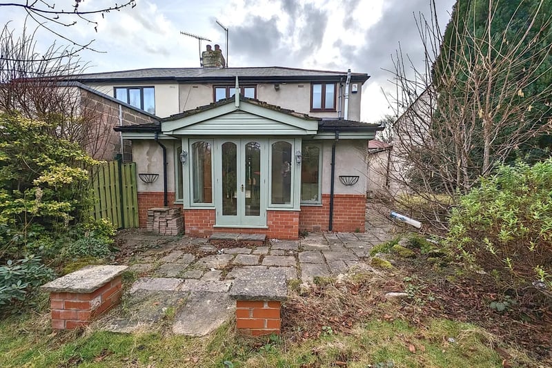 Immediately at the rear of the back door is a patio area and steps leading up to a raised lawn area, bordered with plants and shrubs. Photo courtesy of Zoopla.