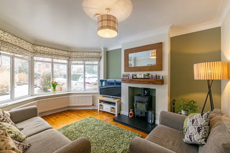 The separate living room is a tranquil space with a log burner and large bay window overlooking the front garden.