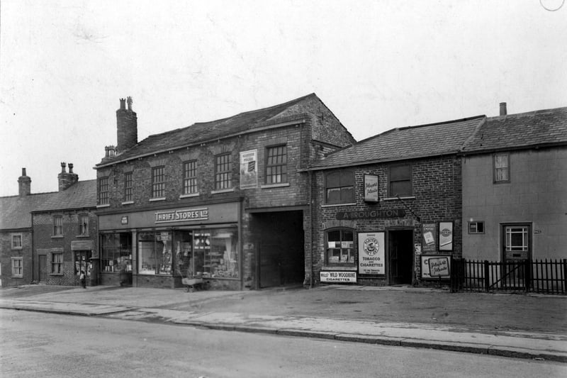 Thrift Stores at number 1059 York Road and A Brougton tobacconists at 1061 York Road, a low height small brick shop. Thrift's has items in the window and a pram outside with a post box to the right. There are small brick cottages adjoining the shops. Pictured in February 1952. 