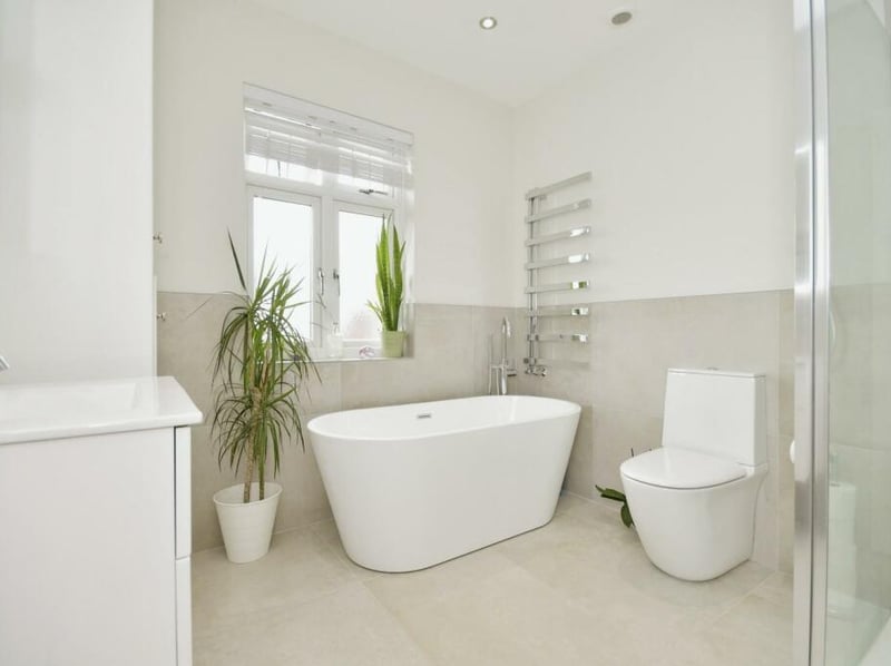 A simple, modern family bathroom with separate bath and rainfall shower units.