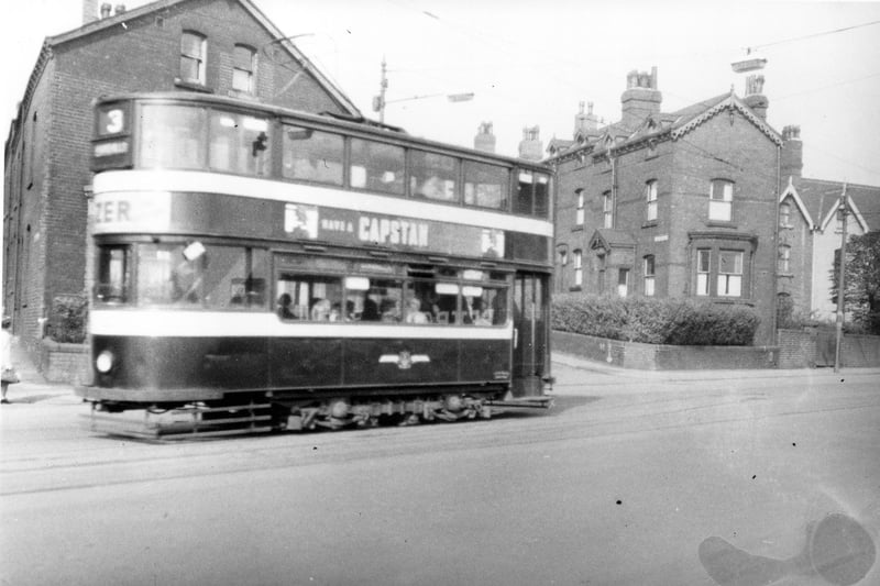 tram on route 3 from Dewsbury Road terminus to Roundhay. It is pictured on Dewsbury Road close to the Crescent Cinema. Tram has adverts for 'Capstan' cigarettes and 'Tizer' on side and front. Pictured in September 1954.