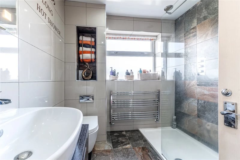 The fully tiled bathroom has a large walk-in shower.