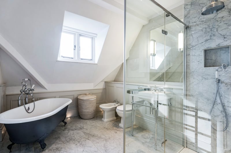 The family bathroom is accessed from the entrance hall with stylish marble tiles, bath, separate shower, WC and basin