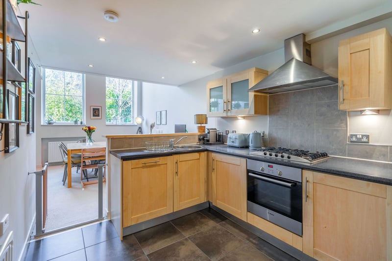 The kitchen hosts traditional wooden cabinets, integrated five gas ring hob and oven and a breakfast bar.