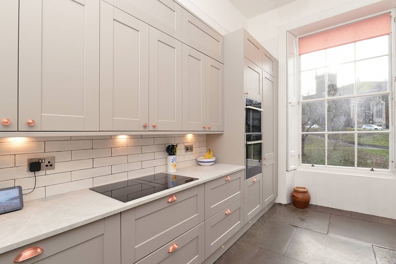 The generous galley-style kitchen enjoys views of Calton Hill. The kitchen has a generous range of base and wall-mounted units that are set against a tiled splashback. The kitchen offers plenty of prep and storage space and there is a range of NEFF integrated appliances.