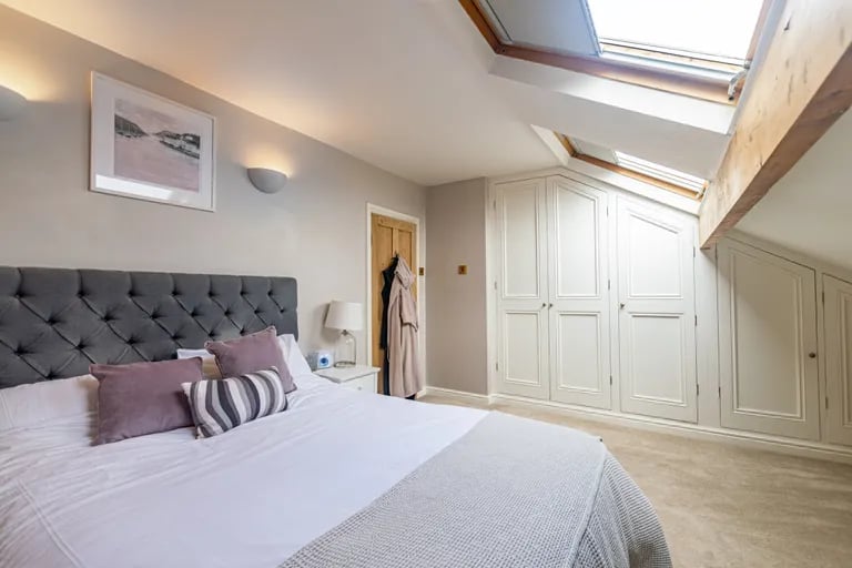 On the second floor are two further bedrooms with exposed ceiling beams and built-in wardrobes.