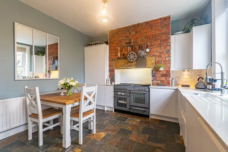 The chimney breast opening with exposed bricks adds to the charm.