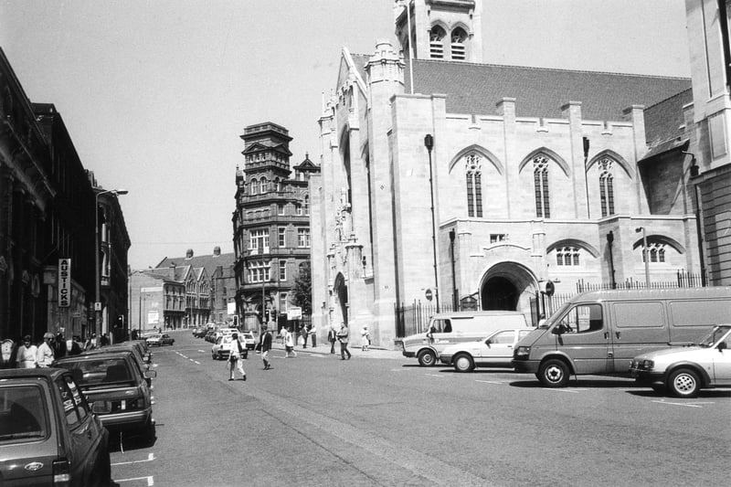 Cookridge Street with St. Anne's Cathedral prominent at the junction with St. Ann Street. Beyond the cathedral the Leonardo Building can be seen at the corner with Great George Street while on the left of the photo is a branch of Austick's bookshops.