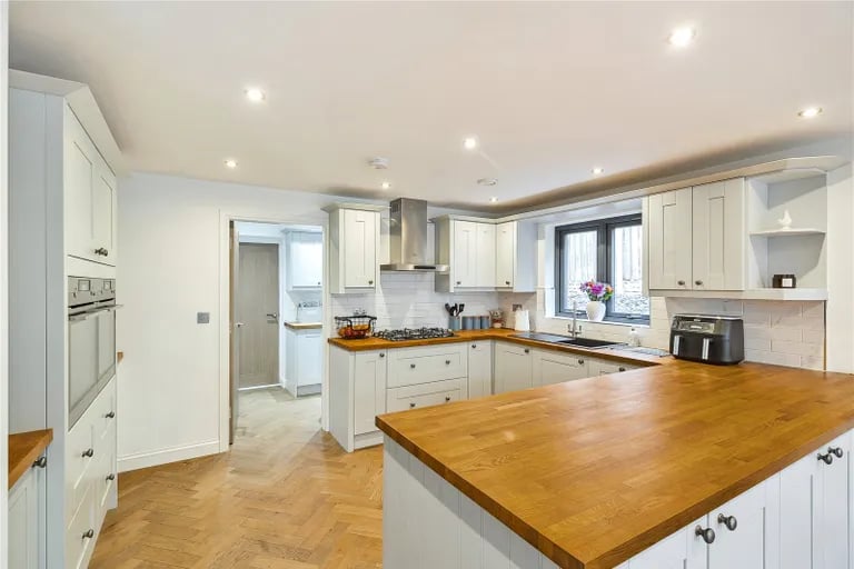 The large open kitchen features a range of units and appliances and lots of work space. 