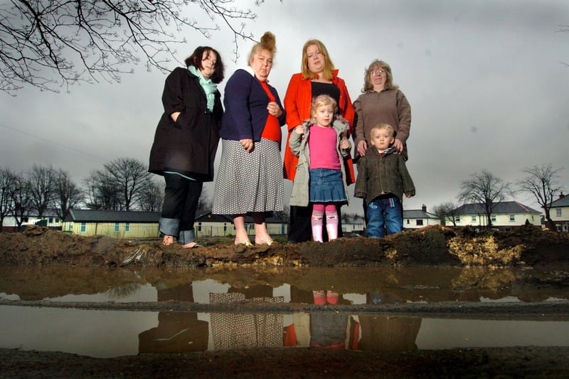 February 2007 and residents of Salmon Crescent claimed that the green space near their homes has been left a muddy mess by council workers. Pictured, from left, are Tasha and Carole Hunting, Rachel Jenkison with children Niamh, and Jacob and Dawn Myers.