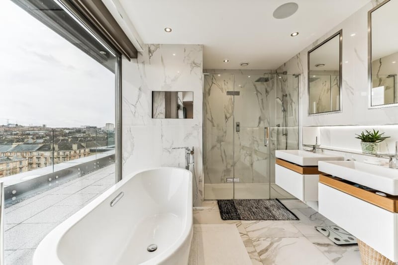 The luxurious en-suite bathroom features his & hers wash hand basins, free standing bath with concealed mirror television and double shower enclosure. 