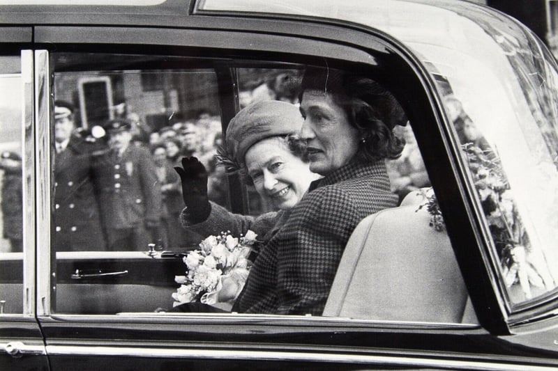 The Queen waves to well-wishers after visiting the Town Hall.