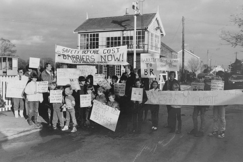 Banner-waving protesters demonstrated against a proposed half-barrier rail crossing in November 1986.