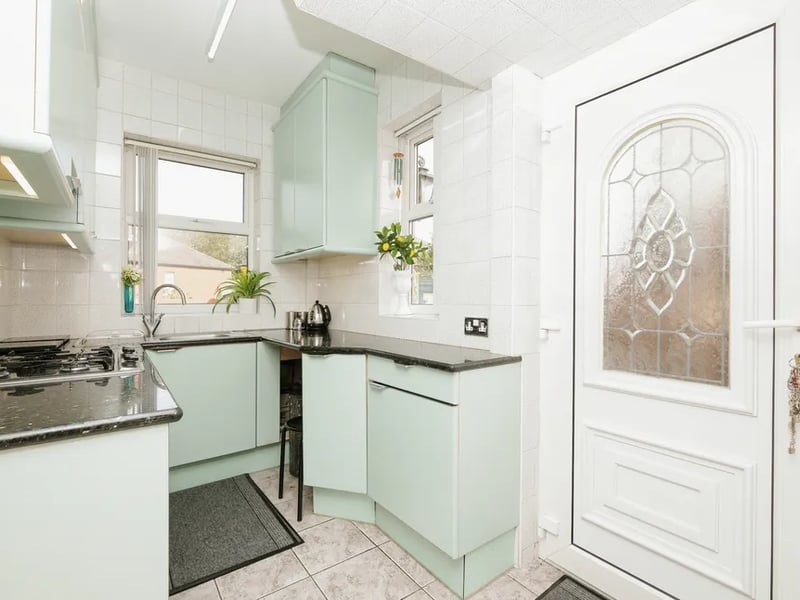 The kitchen is filled with natural light, providing a pleasant space for cooking separate from the dining room.