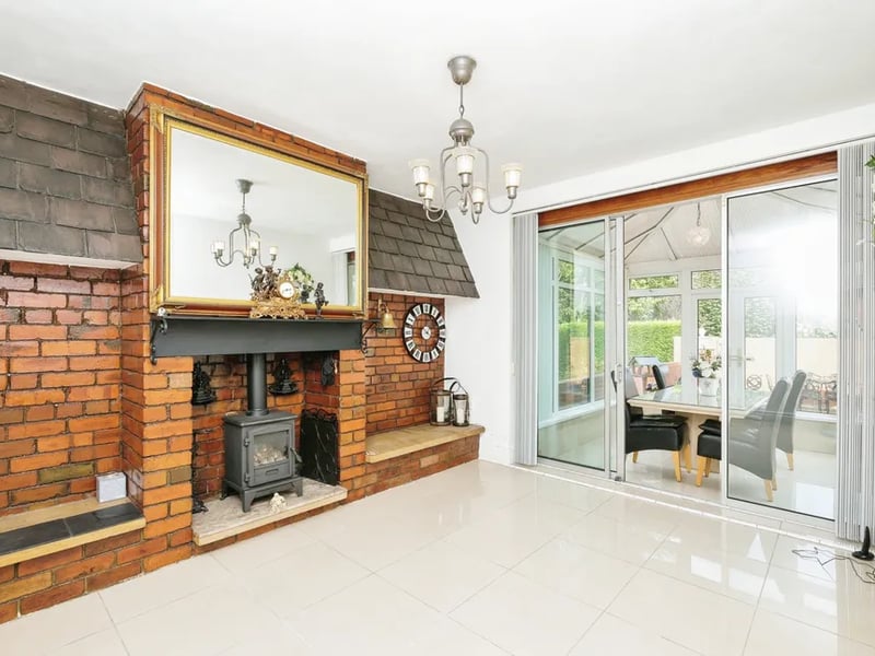 The dining room features an exposed brick wall with fireplace and lovely view of the garden.