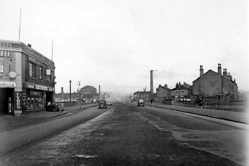 Looking north west along Sheepscar Steet South from the south end in November 1945. Whitelocks garage is visible on the corner with Benson Street. Cars and people are on the street and industrial chimneys can be seen in the background.