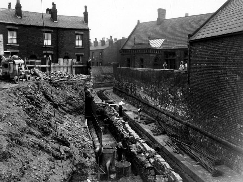 Collapsed retaining wall at Sheepscar Beck near Sheepscar Street South. The area of damage is marked with wire netting and warning lamps. Rubble can be seen in the water including large chunks of the brick wall. Pictured in July 1947.