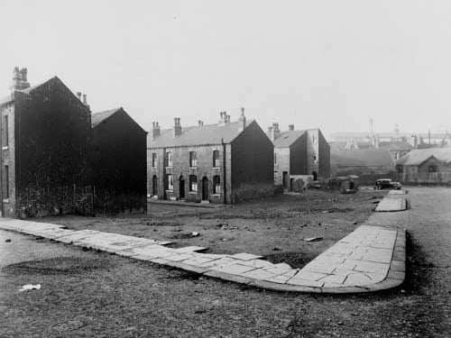 Looking west along Husler Grove from Goxhill Street towards Laycock Place in November 1945. The area has been partly demolished. A car is parked in the distance.