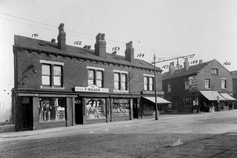 From the left, junction with Greyhound Place, Owen and Robinson, pawnbroker and supplier of household goods is at no.113 York Road. Next right, no.115 Fred Walker, grocer. Harry Jordan has window of fruit and vegetables at no.117 with slogan across window 'Always the best, at market prices'. No.119 is H.Burgon and son, butcher. The entrance to Greyhound Street with Thomas Carkers shop at 121 on the right. Poster for 'OXO' on the wall. Pictured in September 1935