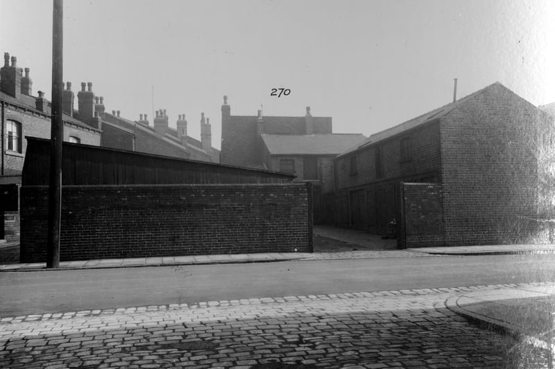 This unidentifiable view across York Road shows a stable yard and stable. There is a brick terrace house to the left. Pictured in September 1935.