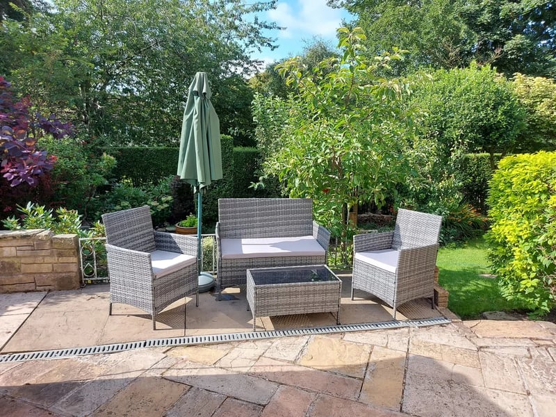 The private garden is surrounded by trees and features a patio.