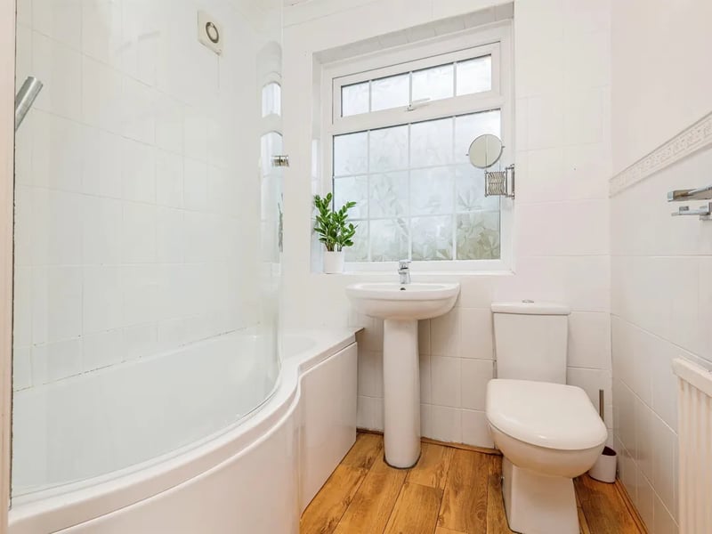 A modern bathroom with bathtub with rain shower over.
