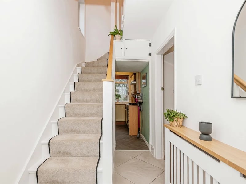 Carpeted stairs in the hallway lead to the first floor where the bedrooms are found.