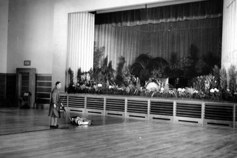 A janitor polishes the floor of the new theatre, part of £60,000 student union building. The stage area can be seen. Pictured in June 1939.