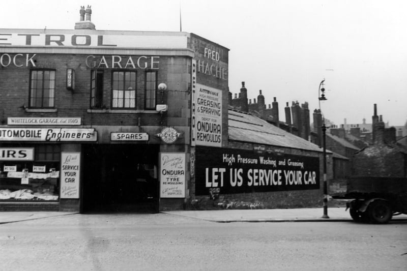 Fred Hache's Whitelock Garage. View of one of the repair bays, with adverts for servicing, remoulds, spares etc. Pictured in July 1946.