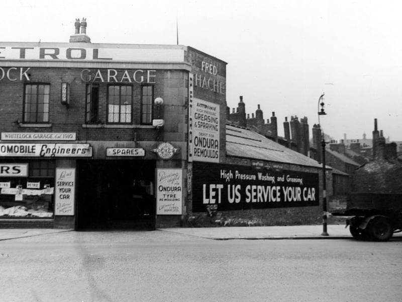 Fred Hache's Whitelock Garage. View of one of the repair bays, with adverts for servicing, remoulds, spares etc. Pictured in July 1946.