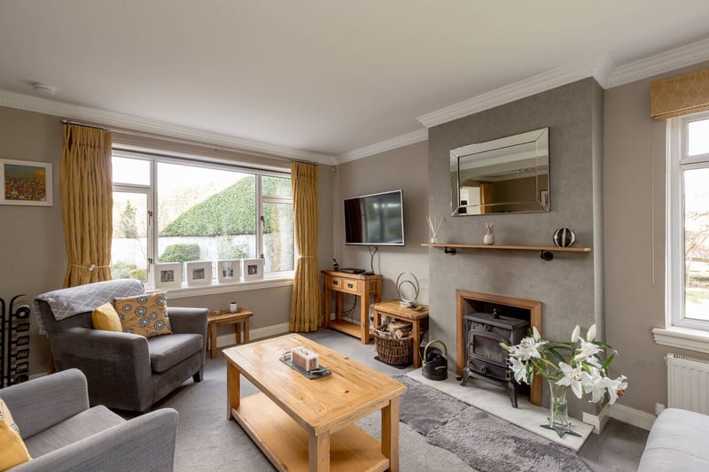 The property's spacious living room with a dual aspect and wood burning stove.
