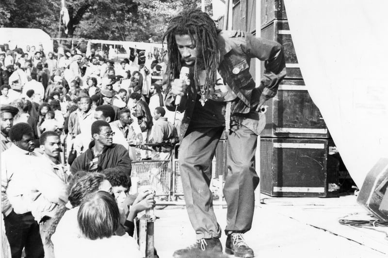 The Black Music Festival held annually in Potternewton Park. It was a free community event sponsored by Leeds City Council and is the biggest Black Music Festival in Europe. This was the fourth Leeds Reggae Concert and included musicians and performers from the Caribbean and the U.S.A. In this image Jamaican Dub poet, Ras Fikre, is performing to the crowds. As well as the more well known artists, the Festival was also a showcase for local talent. Pictured in August 1989. 