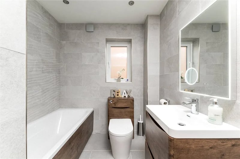 The stylish family bathroom has a modern three-piece suite.