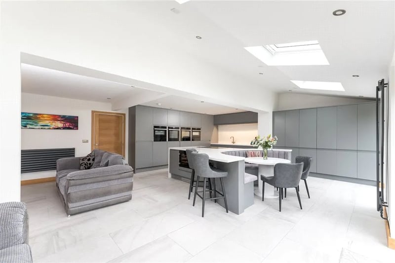 It features a large open kitchen installed in 2022 with isle and bi-folding doors and skylights.