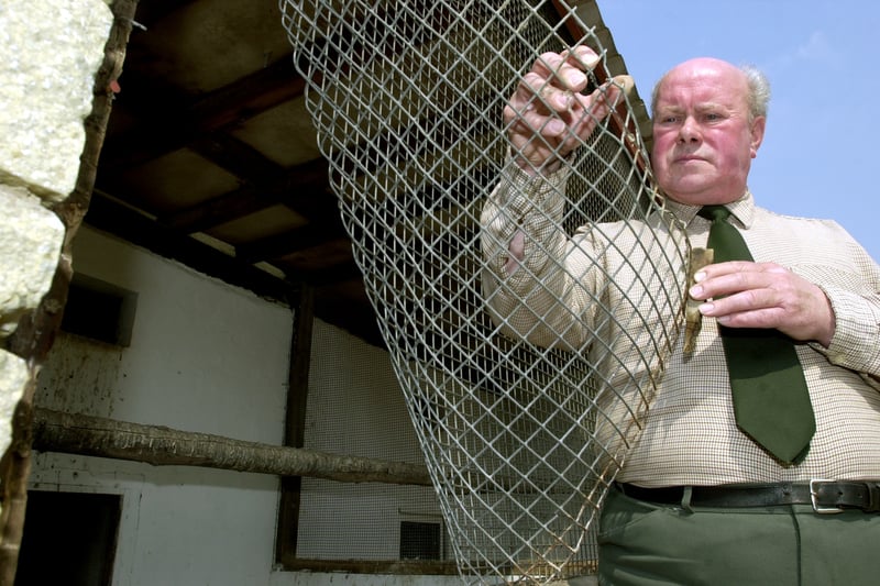 Area officer for Rothwell parks and countryside Ray Platt shows where thieves stole pigeons at the aviary in Springhead Park. Pictured in April 2003.