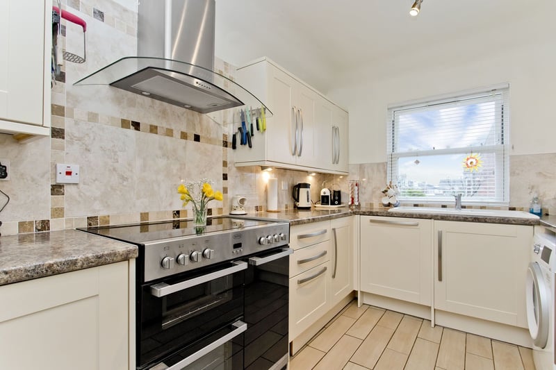 The kitchen has a stylish design, fitted with cream-coloured cabinets and stone-inspired worktops, backed by chic splashback tiles. It incorporates under-cabinet lighting, an electric range cooker, an integrated dishwasher, and space for a fridge/freezer and washing machine.