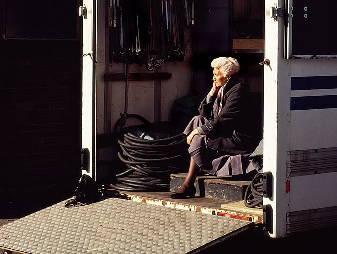 A woman in the sunlight in the back of a van parked in a Glasgow street in March 1990.