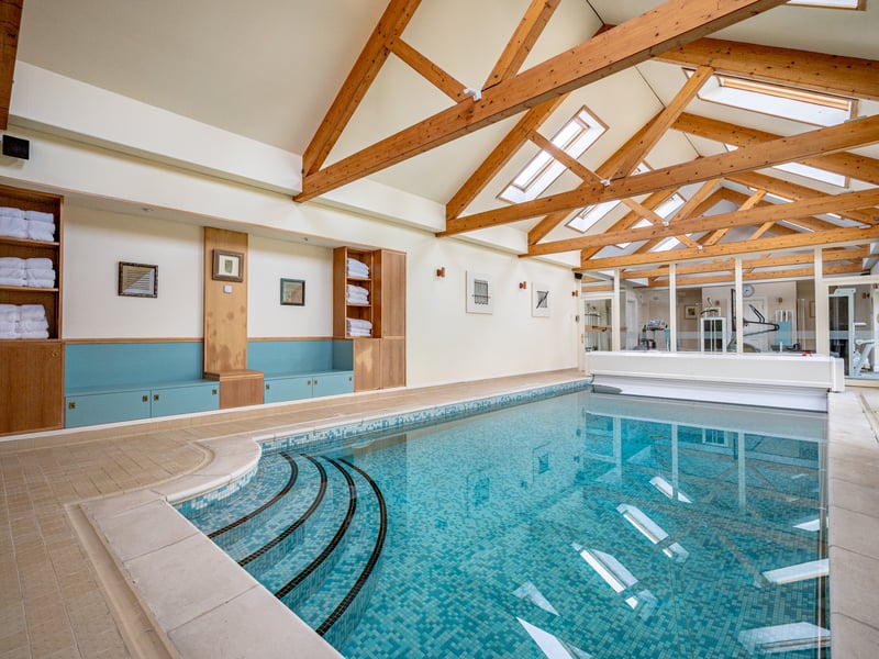 Waterside Farm’s entrance hall leads to a large dining hall, with double doors opening to a drawing room with a beamed vaulted ceiling and library. However, the heart of the home is formed by its rear open-plan kitchen and breakfast area, which has elegant doors opening directly to the property’s outdoor space, and views over the mature garden.
On the opposite side of the ground floor is an impressively large indoor swimming pool with dedicated changing rooms, plus gym facilities, as well as a billiards room and study.
