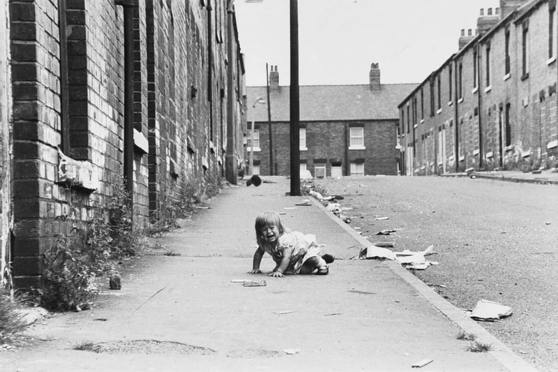 Hard times for 15-month-old Tammy Clarke among the broken glass and debris of Queen Street in July 1979.