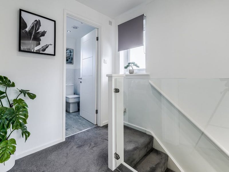 Up the stairs with glass balustrade is the first floor landing.