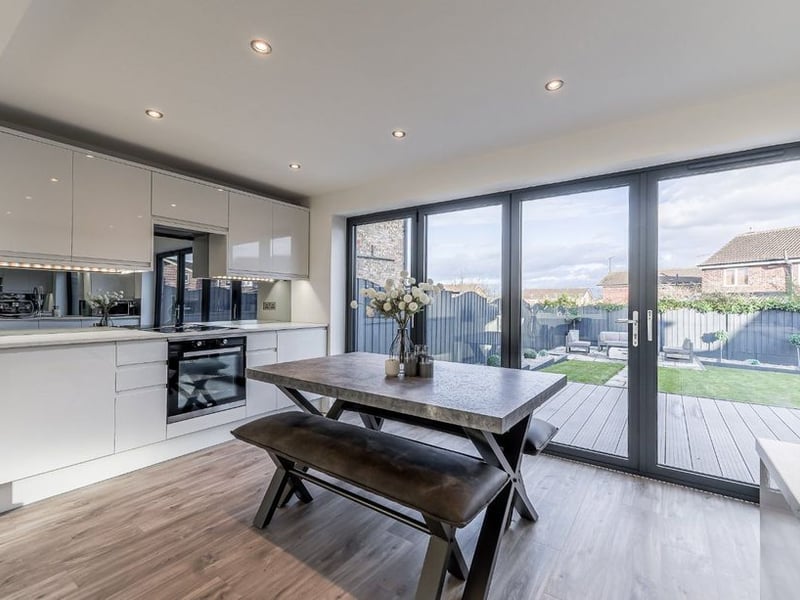 The kitchen has fitted illuminated base and wall units with complimentary work surfaces over.