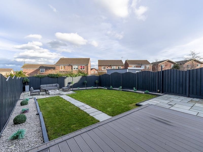 The generous landscaped garden is mainly laid to lawn with composite decking.