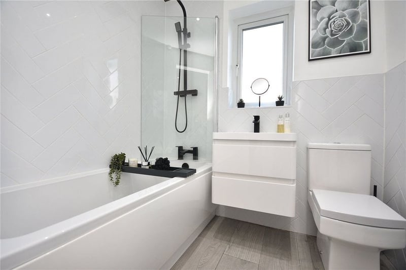 The contemporary house bathroom has a modern three-piece suite in white.